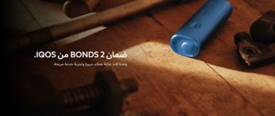 Blue BONDS 2 by IQOS device on a wooden floor beside a tool and a metal gear piece