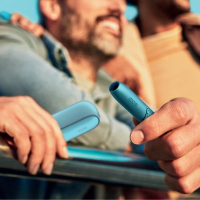 Lit cigarette end compared to IQOS HEETS stick in IQOS 3 DUO holder.