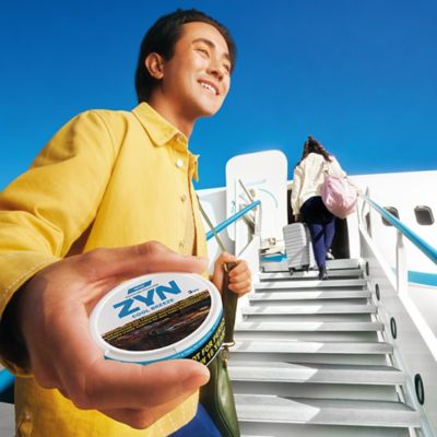 Man holding a ZYN can while boarding the plane