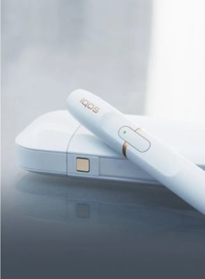 White IQOS 2.4 with a HEET in the holder on a table