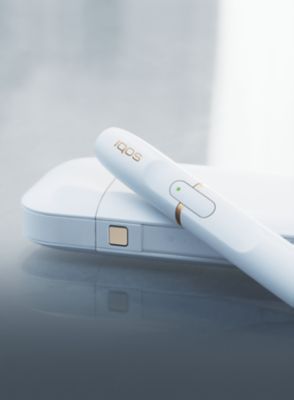 Grey IQOS Duo on a table in a garden
