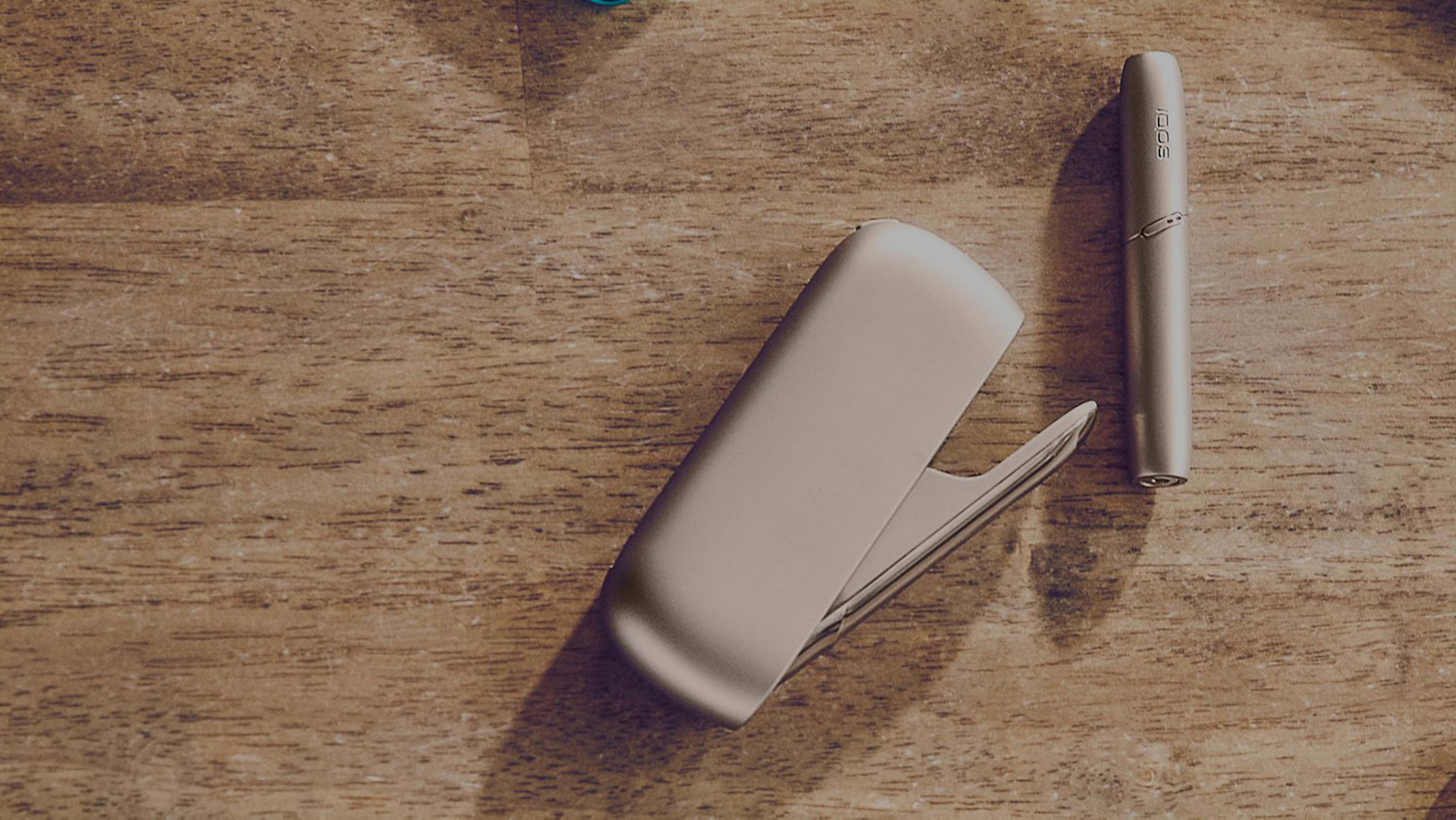 Gold IQOS Duo on a wooden table