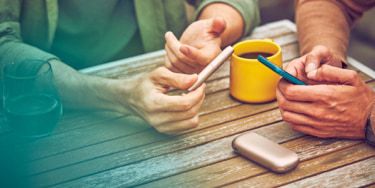 Woman holding her grey IQOS - IQOS charging slowly