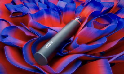 Vape VEEV NOW ULTRA sobre un fondo de flores azules y rojas