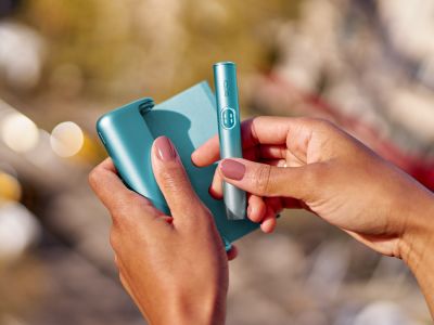 Pengguna mengeluarkan holder IQOS ILUMA i Prime dari pocket charger