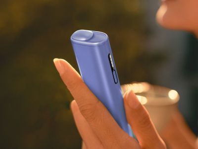 A hand holding the latest IQOS ILUMA i heated tobacco device