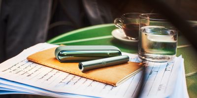 Hands holding an unopened IQOS device box.