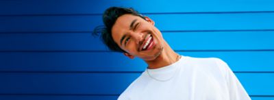 Mrkající muž v bílém tričku na modrém pozadí – ZYN