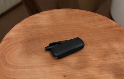 Appareil IQOS noir posé sur une table en bois circulaire