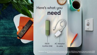 A charging cable being inserted into an IQOS ILUMA PRIME holder.