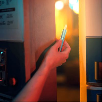 Eine Person hält ein IQOS ILUMA i Holder ins Licht