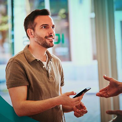 Muž držící mobilní zařízení