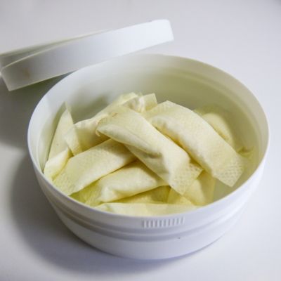 Otevřená krabička s nikotinovými sáčky ležící na bílém stole