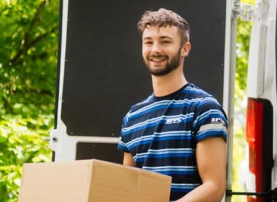 Kurýr PPL nesoucí zabalený balík se zásilkou