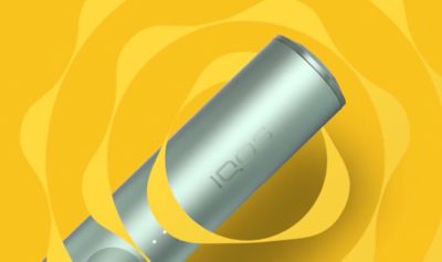 Zařízení IQOS ILUMA na žlutém pozadí.