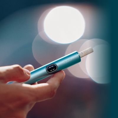 Eine Hand hält ein IQOS ILUMA i Holder