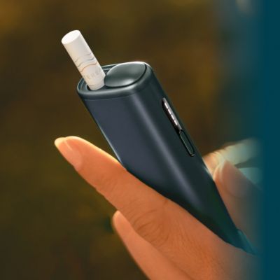 Eine Hand hält ein IQOS ILUMA i ONE Holder