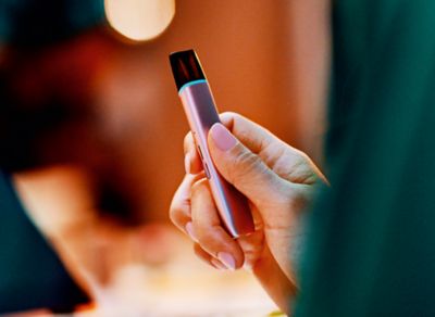 Jemand mit rosanem Nagellack hält ein VEEV ONE Device in der Hand