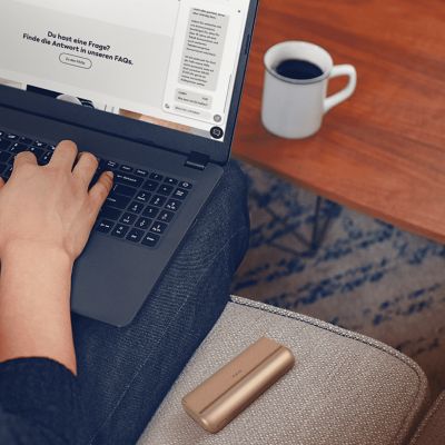 Hände chatten am Laptop über den IQOS Live Chat.