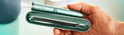 Ein IQOS ILUMA Device und Holder in Moss Green