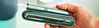 IQOS ILUMA Holder und Charger in der Hand eines Mannes