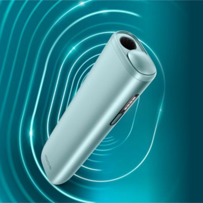 ILUMA i Tabakerhitzer in der Farbe Breeze Blue abgebildet vor einem petrolfarbenen Hintergrund.