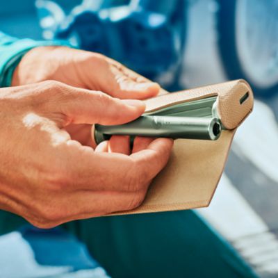 IQOS ILUMA Holder wird aus einem Charger entnommen.