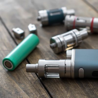 Hand mit einer lila Einweg-Vape