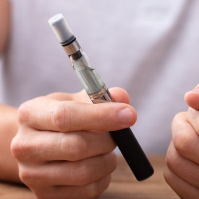 Hände mit einer E-Zigarette und sichtbarem Liquid-Tank