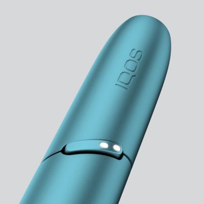 IQOS ORIGINALS ONE Tabakerhitzer neben Reinigungs-Stick und Reinigungsstift auf einem Tisch