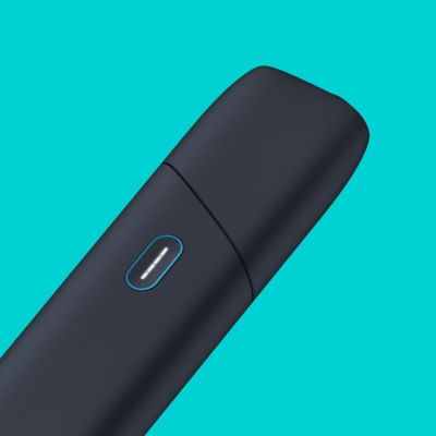 Türkisfarbener IQOS Originals One Tabakerhitzer wird mit einem Kabel aufgeladen