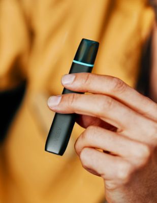 Jemand in einem gelben Pullover hält ein VEEV ONE Device in der Hand