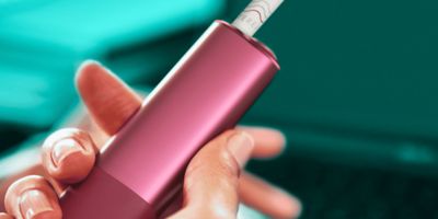 Ein IQOS ILUMA One in der Hand einer Frau.