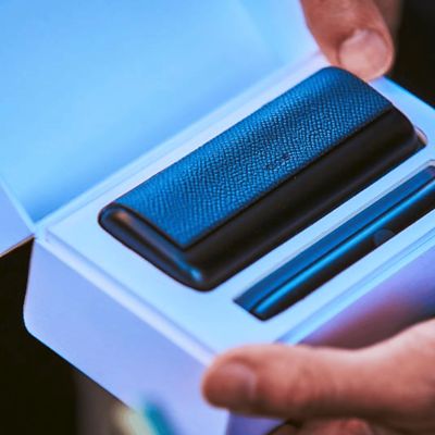 Ein schwarzes IQOS ILUMA PRIME Gerät  in einer geöffneten Schachtel