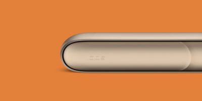 Ein IQOS 3 DUO liegend vor orangem Hintergrund.