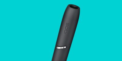 Ein IQOS 3 DUO Holder vor türkisem Hintergrund.
