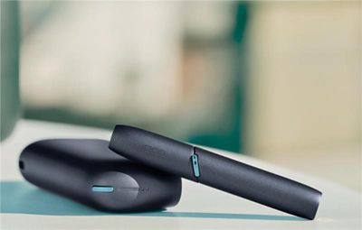 Appareil IQOS noir posé sur une surface avec un arrière plan flou