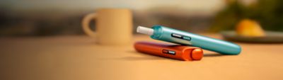 IQOS ILUMA i Series devices on wooden surface