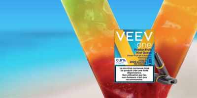 image d’un pack de VEEV ONE Fruit de la Passion, Kiwi et Goyage, saveur uniquement vendue en ligne sur un V évoquant un monde fruité et un fond bleu mer et beige sable, il est marqué : nouvelle saveur, uniquement en ligne, Fruit de la Passion, Kiwi & Goyage et un bouton cliquable « J’achète » afin d’accéder directement au produit