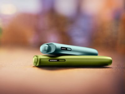 Deux Iqos Iluma I One couleur Aigue-marine et vert anis sur fond mutlicolore.