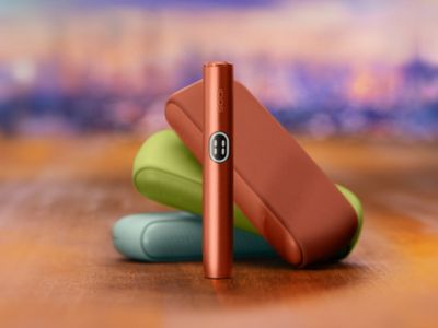 Trois Iqos Iluma i couleur Aigue-marine, terracota et vert anis sur fond mutlicolore.