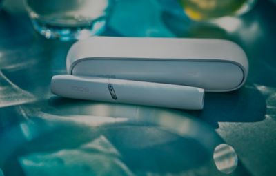 Zoom sur un appareil IQOS avec un fond dégradé de couleurs bleues 