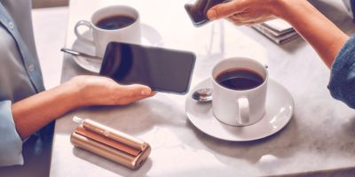Zwei IQOS Nutzer bei einer Tasse Kaffee