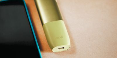 IQOS ILUMA neben einem Laptop