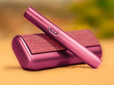 Držalo  IQOS ILUMA i PRIME v bordo barvi Garnet Red na žepnem polnilniku.