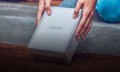 A woman with an IQOS box.