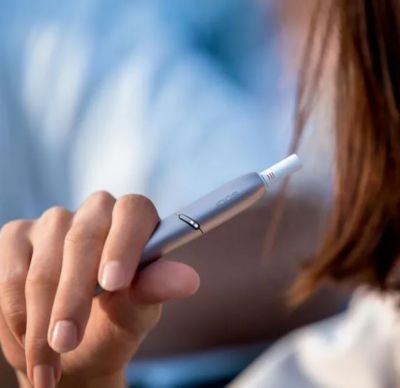 Cigarette filter with brown combustion stains compared to IQOS HEETS stick in IQOS 3 DUO holder with no equivalent stain