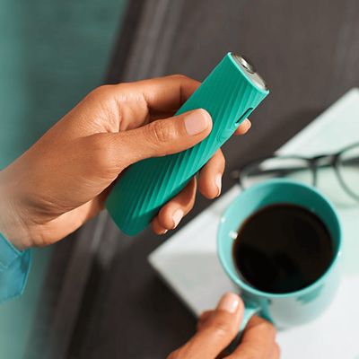 Ein IQOS ILUMA ONE Gerät mit Hülle wird in einer Hand gehalten