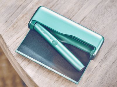 Ein IQOS ILUMA PRIME Charger liegt aufgeklappt auf einem Tisch