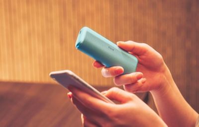 Person hält Smartphone und IQOS Kit in der Hand.